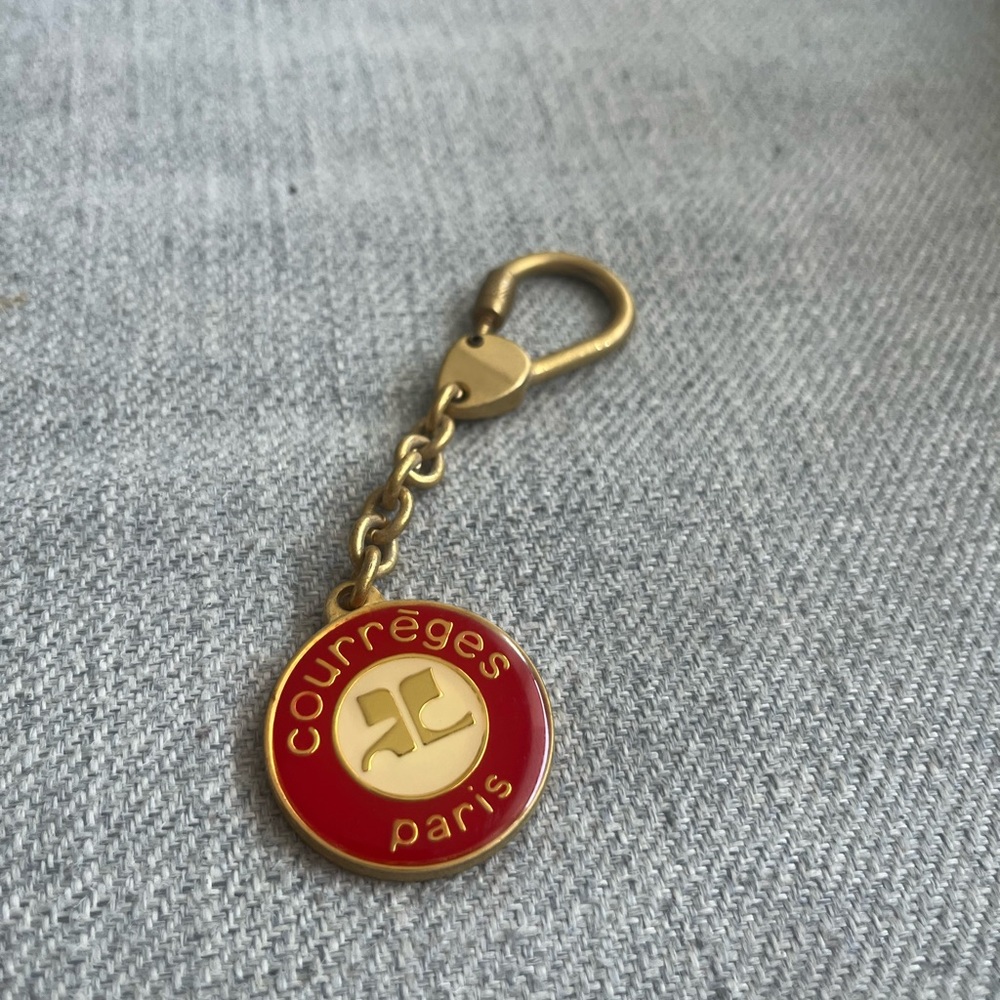 Courrèges logo key chain in gold and red.